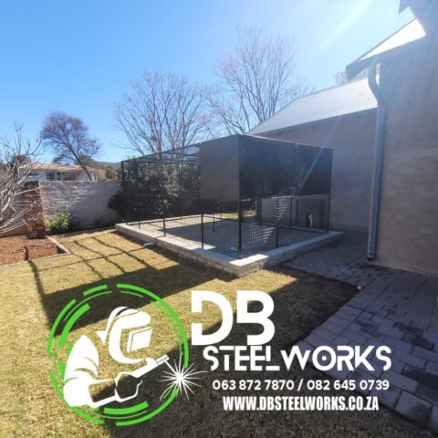 Large custom-built steel enclosure by DB Steelworks, perfect for pets or storage, featuring durable mesh panels and a concrete foundation.